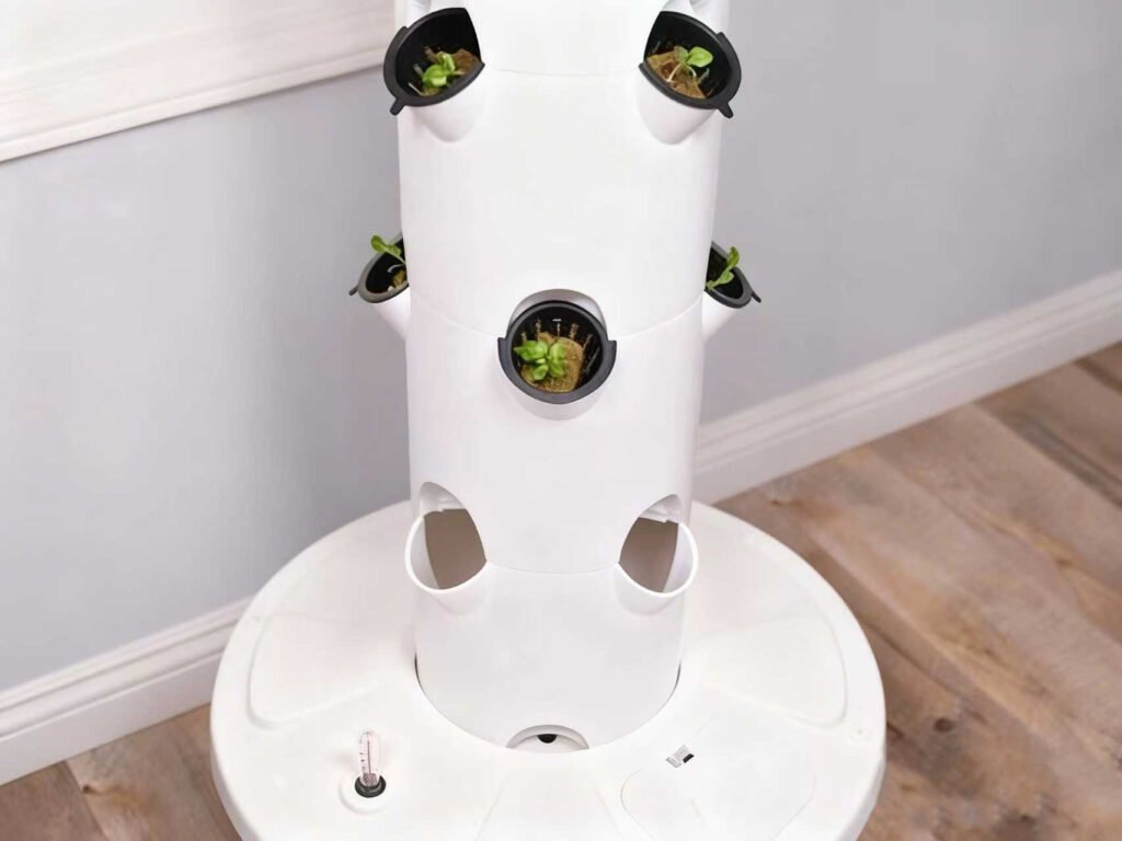Indoor vertical hydroponic tower system with seedling plants, designed for commercial lettuce growing and space-saving vertical farming